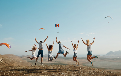 Group adults jumping together during early sunset